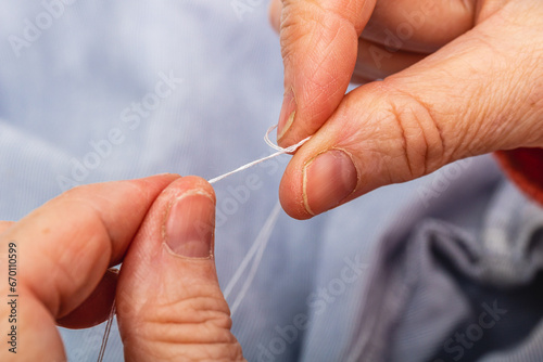 Photo close up extreme horizontal  hands mature adult caucasian woman knotting thread Tailor concept