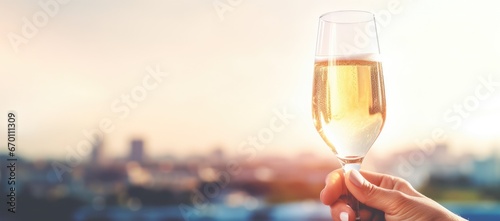 A glass with champagne or wine close-up on the blurred background of the urban area photo