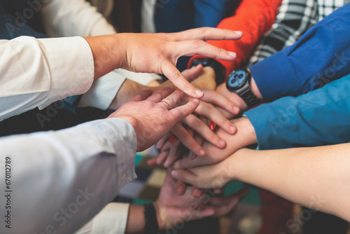 Group team of young people stacking hands together during contest competition, corporate business teamwork and support, coworkers and colleagues, team members hands of partners stacked for success © tsuguliev