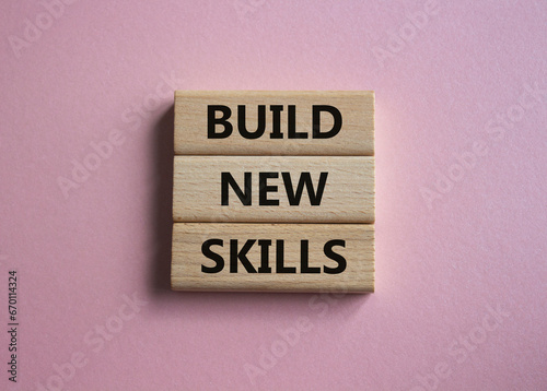 Build New skills symbol. Concept word Build New skills on wooden blocks. Beautiful pink background. Business and Build New skills concept. Copy space