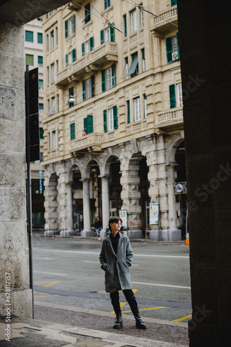 A young girl in a coat with short black hair walks through the streets of a European city. Lifestyle. It's autumn outside © katya