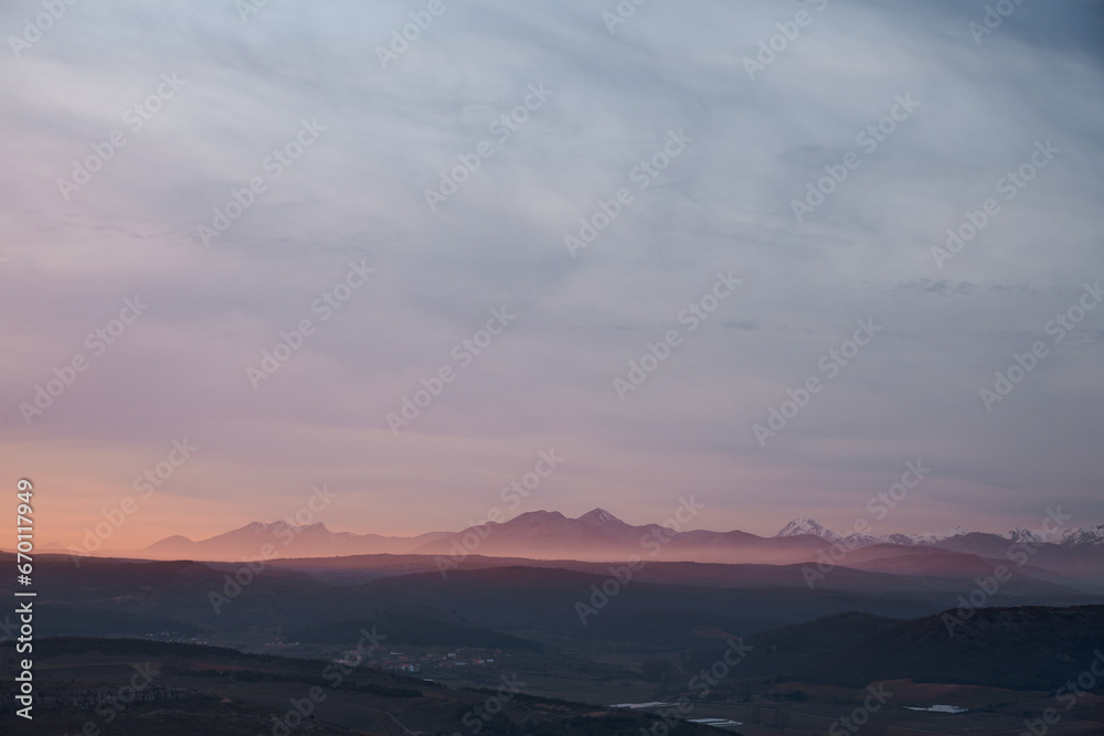 A pink iluminated mist covers the valley in a winter sunset in Spain