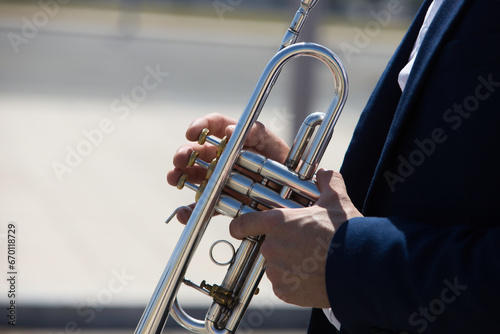 Detail of the hands of a trumpet player playing the musical instrument. The hand raises and lowers the pistons of the trumpet. October 1 st international day of music