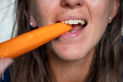 Woman eats food. Woman eats carrot. Close shot of girl eating carrot. Face while eating carrots.