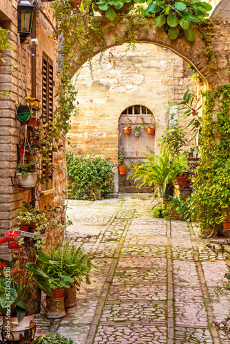 Floral alley with arch in italian beautiful little town of Spello, Perugia. Umbria region.