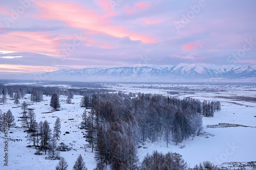 Cold snowy mountain landscape at sunset. Panoramic view of snowy mountain peaks and slopes of North Chuyskiy ridge at sunset. Russia, Siberia, Altai mountains.