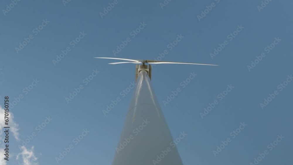 Wind turbine view from the ground looking straight up the tower on mostly clear day Wind turbine view from the ground looking straight up the tower on mostly clear day