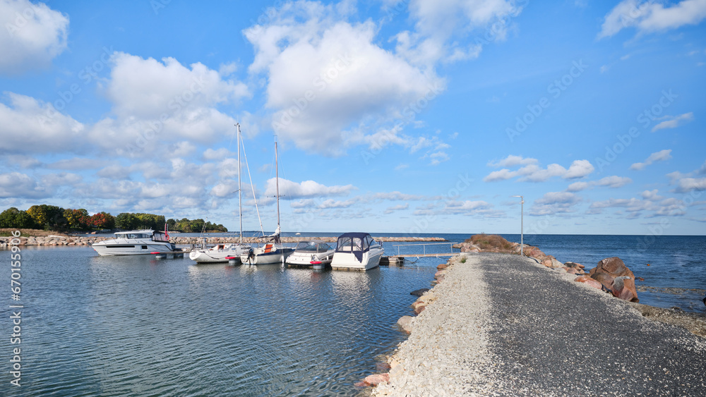 A group of boats are docked on the water. Neeme harbor in Northern Estonia.