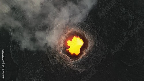 Erta Ale, Danakil Depression, Ethiopia. Aerial view of active volcano smoking and lava activity. Cinematic drone footage of volcanic pit at sunset. Famous adventure travel destination landmark.