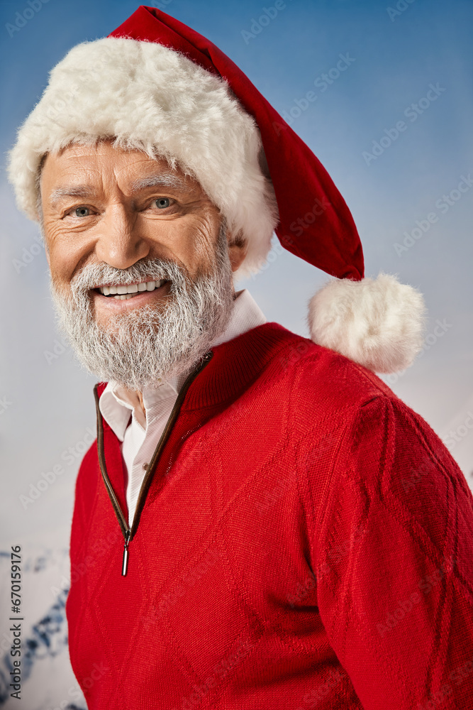 portrait of happy Santa with white beard in red hat smiling cheerfully at camera, winter concept