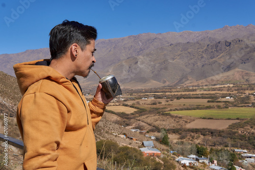 close-up of a brown latin man in solitude and relaxed, drinking mate enjoying the landscape from a balcony in tafi del Valle, Tucuman, Argentina. argentine customs photo