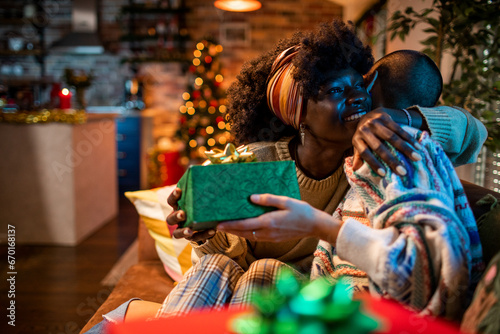 Joyful lesbian couple exchanging gifts during the Christmas season photo