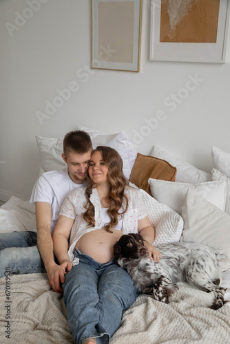 Couple in love, pregnant girl and guy with dogs on bed, bright photo © Stanislava