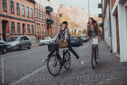 Two happy girlfriends shopping on bikes in the city