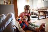 Playful siblings share a joyful moment in the living room