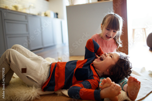 Playful siblings share a joyful moment in the living room photo