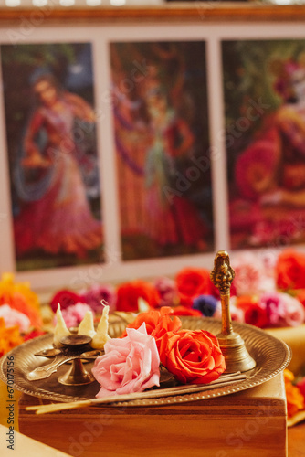 Colourful Hindu altar with offerings for a kirtan celebration honoring Krishna an other deities of the religion with mantras, flowers, rosas and a puja cleansing with the elements photo