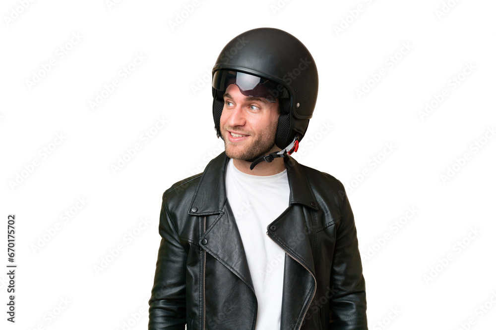 Young caucasian man with a motorcycle helmet isolated on green chroma background looking to the side and smiling Young caucasian man with a motorcycle helmet isolated on green chroma background looking to the side and smiling