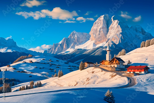 snowy winter landscape with houses, mountains and blue sky