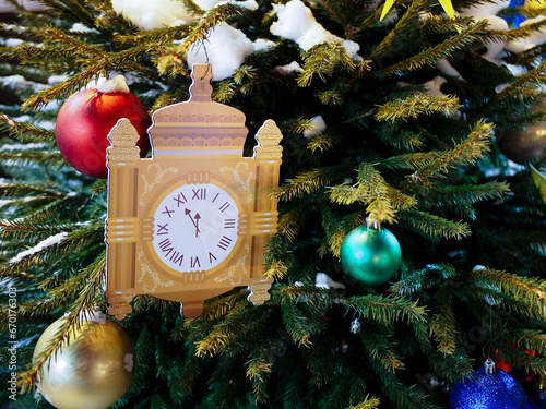 Christmas tree decorated with toys and bright lights, the hands on the clock approaching midnight.