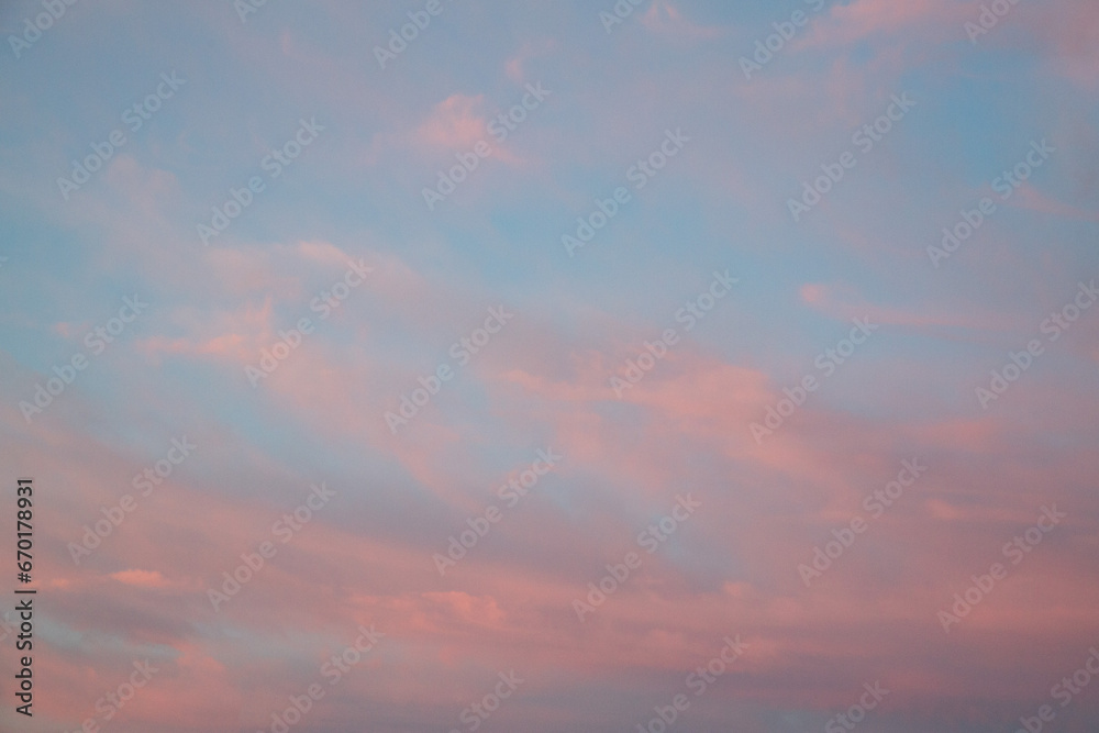 Blue sky with pink sunset clouds. Cloud texture, background.