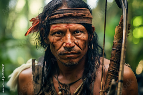 Generative AI image of an indigenous male warrior from the Amazon looking at camera, equipped with traditional bow and arrow, adorned with tribal markings, set against a dense rainforest backdrop photo