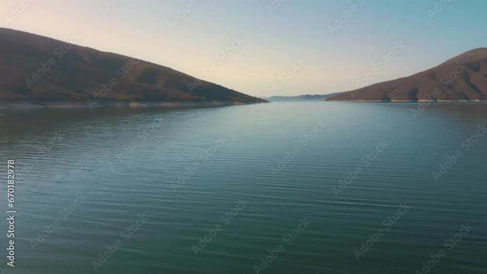 Aerial drone flying over a lake, water dam, with mountains at sunrise. Beautifull dreamy landscape view. Coastline with boats. Pacefull landscape. Cabra Corral, Salta Argentina. Aerial drone flying over a lake, water dam, with mountains at sunrise. Beautifull dreamy landscape view. Coastline with boats. Pacefull landscape. Cabra Corral, Salta Argentina.