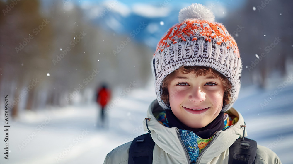 Young skier in knitted hatstands against backdrop of winter landscape and smiles.