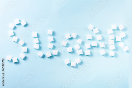 Sugar word in sugar cubes on blue background © neirfy