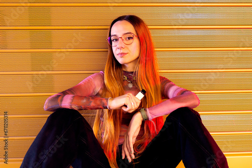 Contemplative young woman posing with e-cigarette photo