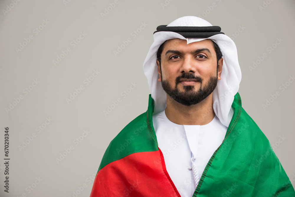 Obraz premium Arabian man wearing traditional emirati dishdasha kandura in studio - Portrait of middle-eastern male adult with beard