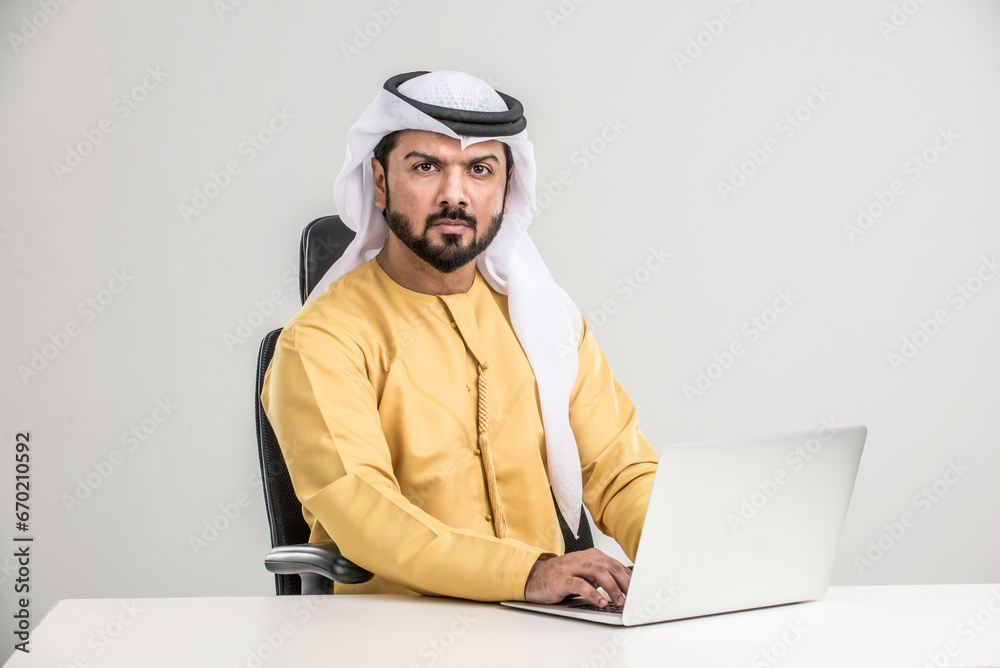 Arabian man wearing traditional emirati dishdasha kandura in studio - Portrait of middle-eastern male adult with beard Arabian man wearing traditional emirati dishdasha kandura in studio - Portrait of middle-eastern male adult with beard