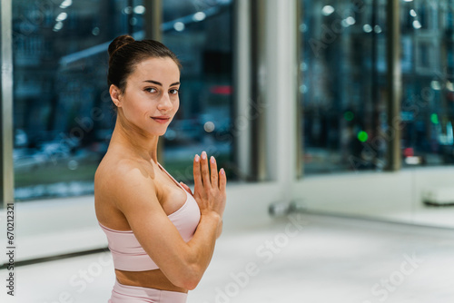 Beautiful sportive woman training in a gym - Pretty young girl doing yoga in a fitness sport club © oneinchpunch