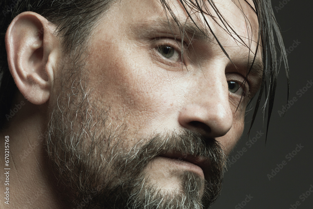Obraz premium Fabulous at any age concept. Profile portrait of 45-year-old man standing over dark gray background. Wet hair. Close up. Studio shot