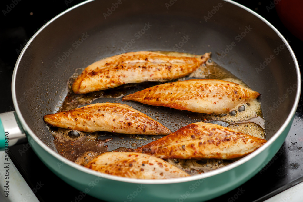 Small fish fillet fried in a frying pan. Cooking fish without oil. Small fish fillet fried in a frying pan. Cooking fish without oil.