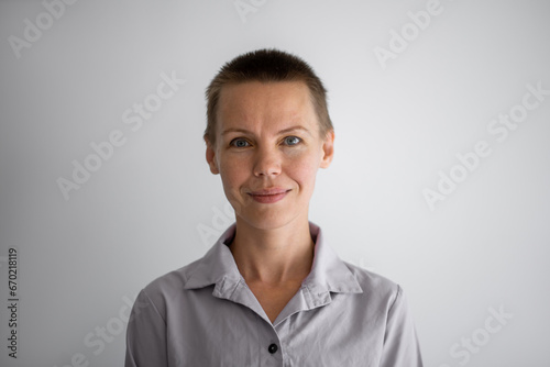Portrait of a woman with a short haircut looks smiling at the camera. Manager, resume photo.