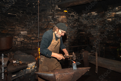 Blacksmith at work in historic workshop photo