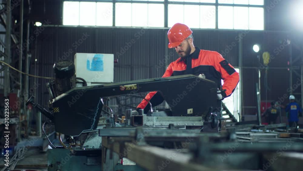 In front of the camera charismatic man factory worker at industrial zone working over the heavy machinery wearing safety equipment In front of the camera charismatic man factory worker at industrial zone working over the heavy machinery wearing safety equipment