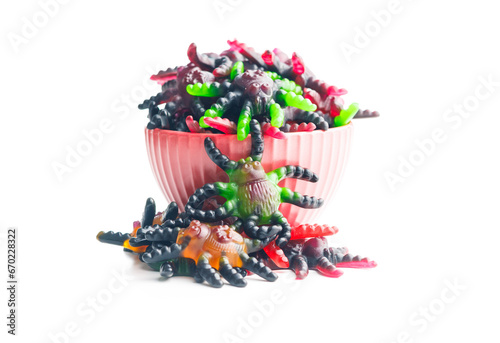 Scary sweet jelly spiders. Halloween candies in bowl isolated on white background.