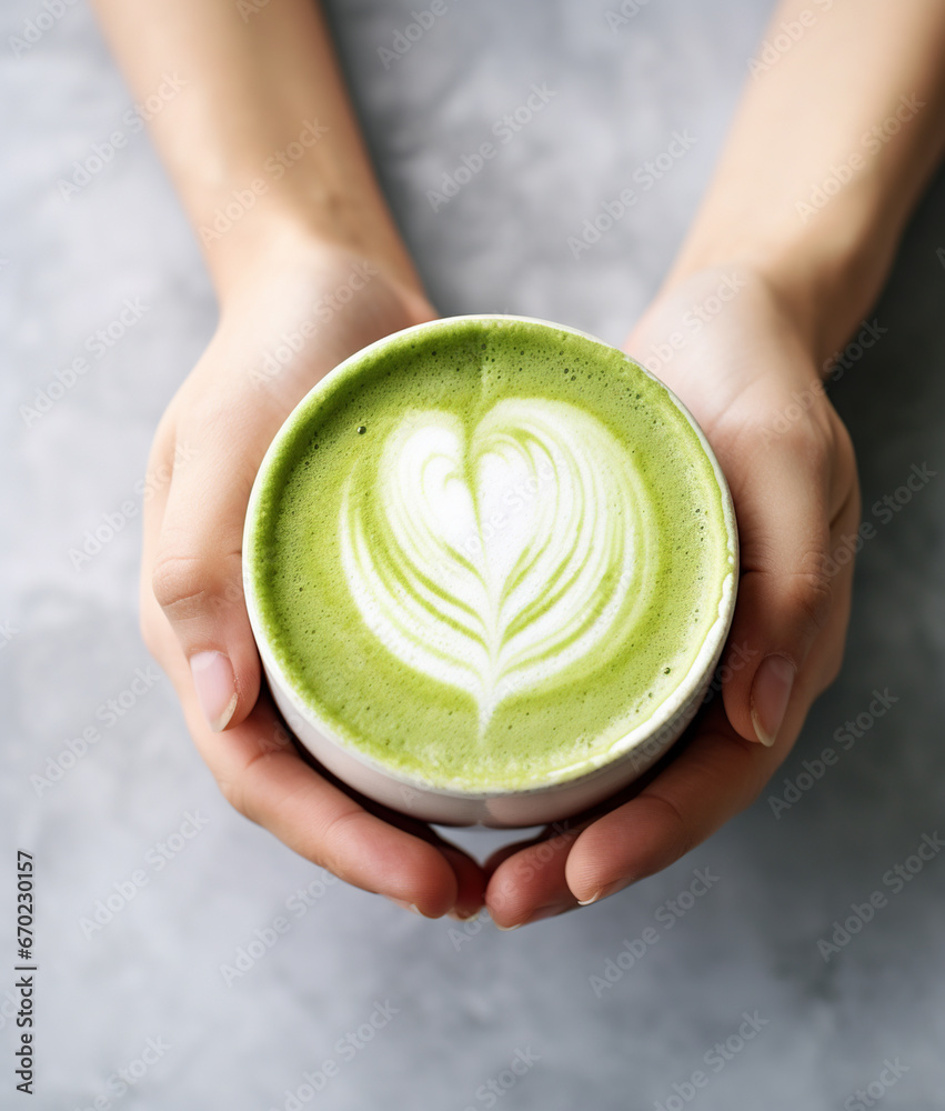 Female hands holding a cup of matcha latte - obrazy, fototapety, plakaty 