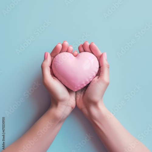 Flat lay photography of two hands holding pink hart on their palms against pastel blue background
