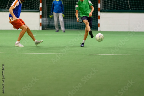 Players in action on five a side match. Sport concept. Indoors hall with artificial turf. photo