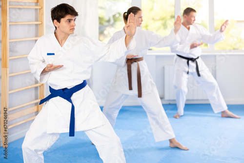 Kata karate teacher conducts classes and performs movements and fighting techniques together with students to prepare them for competitions.