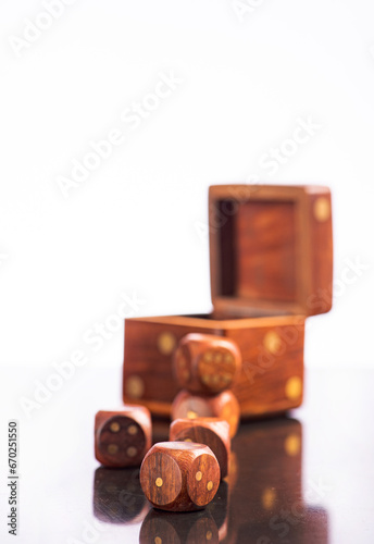Wooden dice, a beautiful composition with wooden dice on a reflective surface with a light background, selective focus.