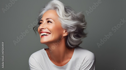 Beautiful gorgeous 50s mid age beautiful elderly senior model woman with grey hair laughing and smiling. Mature old lady close up portrait. photo