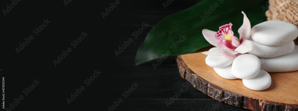 Spa stones and orchid flower on dark wooden background with space for text Spa stones and orchid flower on dark wooden background with space for text