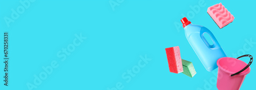 Flying cleaning supplies on light blue background with space for text
