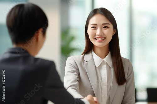 Young Asian business woman, against the background of a working office