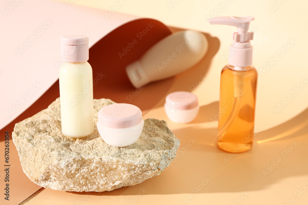 Stone with set of travel cosmetic products on color background Stone with set of travel cosmetic products on color background