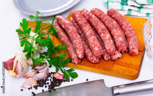 Fresh raw sausage (Longaniza) on kitchen board in restaurant